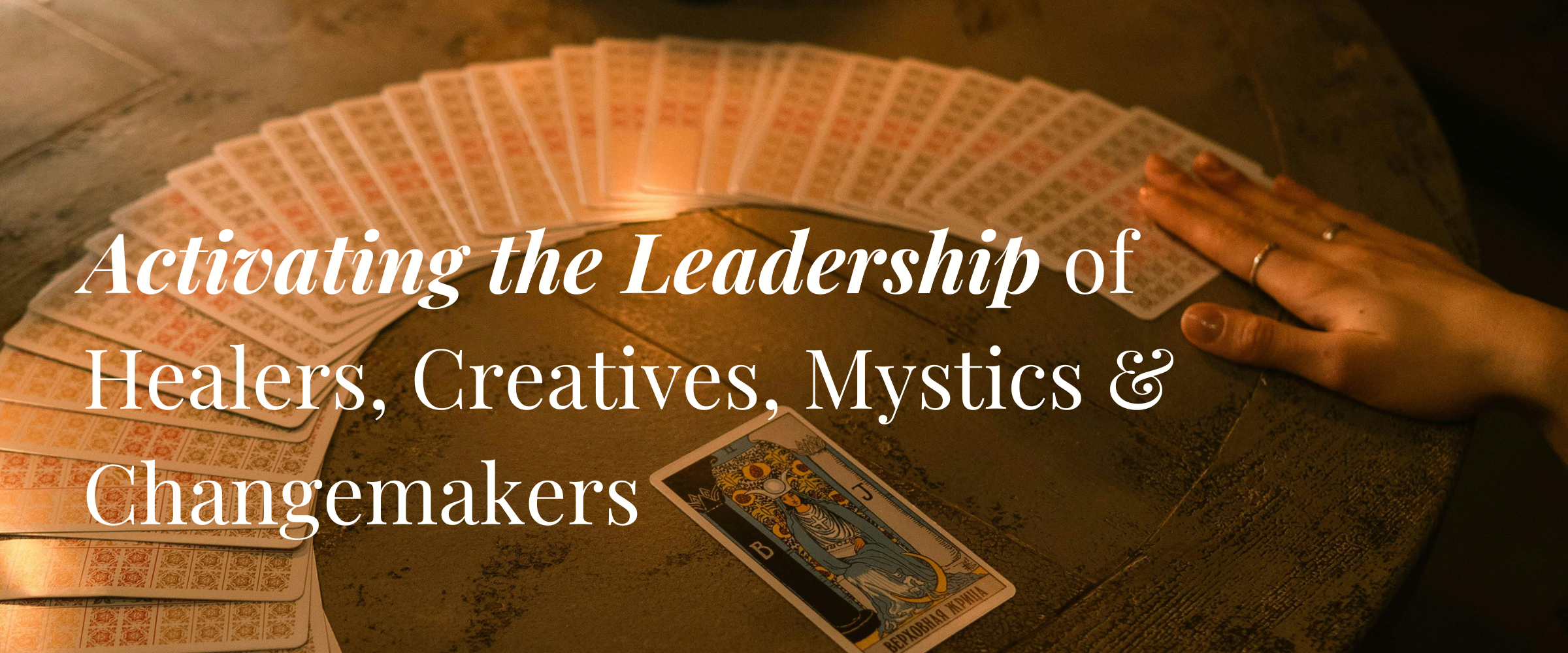 The Return Images(1) An image of a deck of tarot cards spread in a semi-circle across a wooden table, with one card overturned. Over the image are the words: "Activating the Leadership of Healers, Creatives, Mystics and Changemakers"